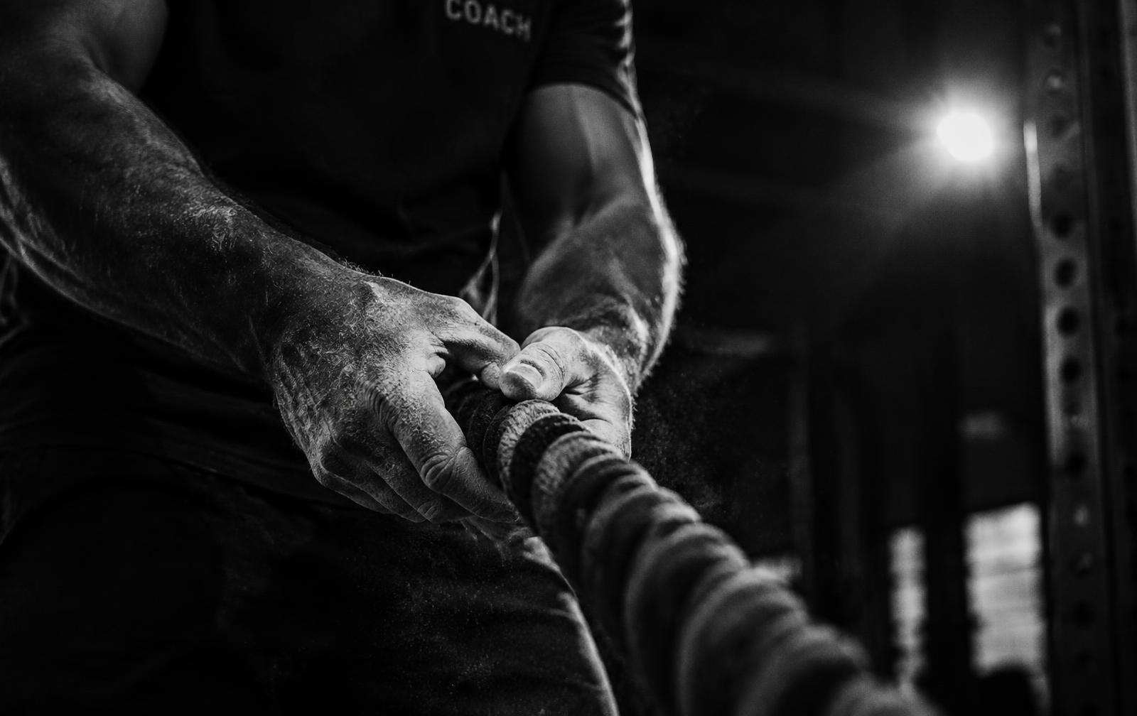 Coach gripping a battle rope